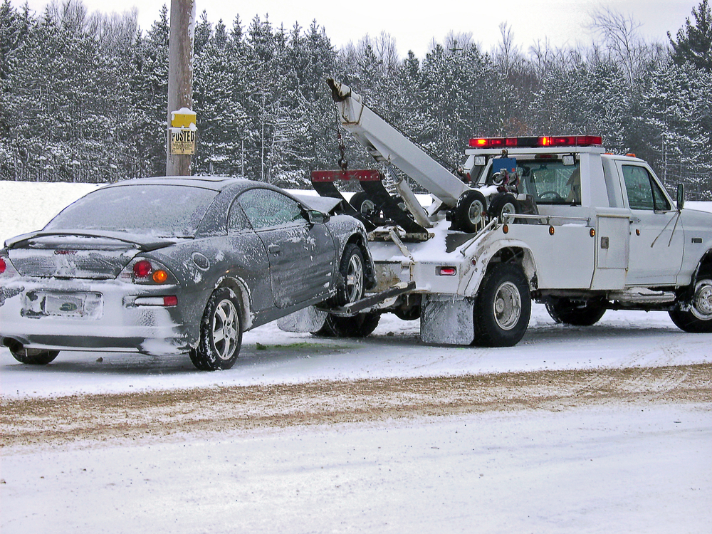 Tow,truck,towing,wrecked,car,in,winter